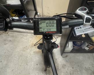 Close-up view of electric scooter handlebars with a digital display and grip.