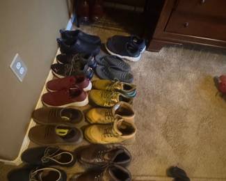 Collection of men's shoes neatly lined up on a shoe rack and on the floor.