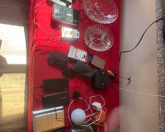 Red wall-mounted storage rack holding spools of wiring, rods, and other small tools.