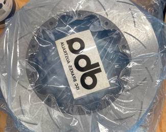 Pair of slotted brake rotors wrapped in plastic packaging.