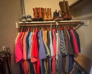 Closet rod with colorful shirts and blouses hanging underneath, with shoes lined up on the top shelf.