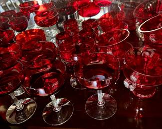 Cranberry glass stems, cups, dishes.