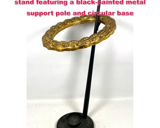 Lot 415 Floorstanding umbrella or cane stand featuring a blackpainted metal support pole and circular base