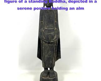 Lot 1082 Southeast Asian carved wood figure of a standing Buddha, depicted in a serene posture holding an alm