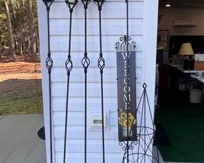 Wrought iron tiki torches, double shepherd's hook and an obelisk trellis