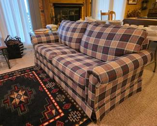 Plaid loveseat sofa bed with Simmons mattress, area rug