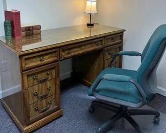 Two Column Wood Desk With Glass Top Includes Chair And Accessories - Condition: worn needs to be refinished 52 inches long by 24 inches wide and 31 inches tall includes green steel case brand office chair, lamp and accessories Pet free smoke free