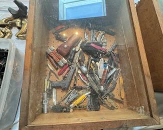 Glass-top display case filled with vintage pocket knives, multi-tools, novelty miniatures, and collectible smalls. Great assortment of knives and gentleman’s accessories for collectors, everyday carry fans, and resellers.