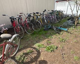 Outdoor sale area with a lineup of vintage and used bicycles, trikes, scooter parts, and bike accessories along the fence. Great selection for riders, restorers, parts buyers, and pickers looking for project bikes and outdoor finds.