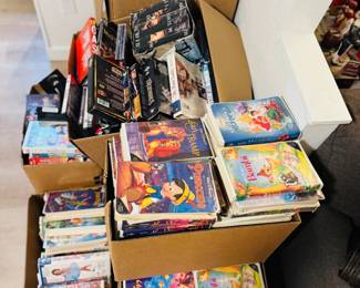 Boxes full of DVDs and VHS tapes including Disney classics, family movies, and mixed film titles. Large media lot for collectors, resellers, and anyone looking for vintage VHS, DVDs, and nostalgic movie favorites.
