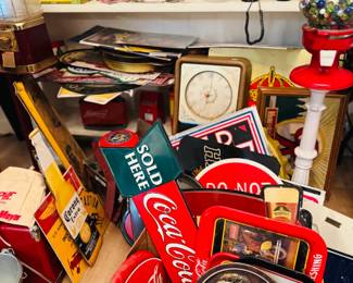Vintage advertising and soda memorabilia area featuring Coca-Cola signs, serving trays, tins, glass bottles, gumball machine, barware, tobacco tins, and mixed retro display pieces. Great selection of red-hot advertising collectibles for Coke lovers, sign collectors, decorators, and resellers.
