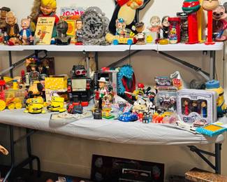 Vintage toy and character collectibles display featuring Sylvester, PEZ dispensers, robots, tin toys, novelty items, comic and cartoon memorabilia, and vintage slot machines. Fun mix of retro pop culture, advertising pieces, and collectible toys for display, collectors, and resellers.