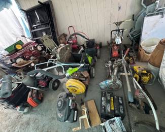Covered outdoor/tool area with lawn mowers, yard tools, small engines, wagon, shop equipment, garage hardware, and assorted repair or project pieces. Great selection for mechanics, tinkerers, landscapers, parts buyers, and picker-style shoppers.
