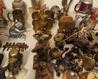 Animal and Americana collectible table featuring eagle statues, brass and metalware, figural decor, steins, primitive tools, and unusual vintage smalls. Great assortment of patriotic, rustic, and one-of-a-kind display pieces for antique buyers, collectors, and resellers.