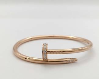 This iconic Cartier Juste un Clou bangle bracelet is crafted in solid 18K gold and features the signature nail motif, fully set with brilliant pavé diamonds that create exceptional brilliance and refined luxury. The bold, sculptural design transforms an everyday object into a striking statement of modern elegance, reflecting Cartier’s innovative and instantly recognizable aesthetic. Featuring the highly sought-after full diamond pavé configuration, this bracelet represents a more collectible and desirable example from Cartier’s renowned Juste un Clou collection.