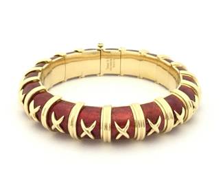 Striking Tiffany & Co. bracelet designed by Jean Schlumberger, crafted in solid 18K yellow gold with rich red enamel panels. The iconic Croisillon design features repeating gold cross motifs over the enamel, a signature element of Schlumberger’s imaginative and sculptural jewelry style. Bold and highly recognizable, this bracelet reflects the distinctive craftsmanship and artistic vision associated with Tiffany & Co.’s most celebrated designer.