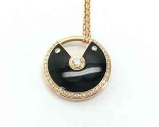 This elegant Cartier Amulette de Cartier pendant necklace is crafted in solid 18K gold and features a striking black onyx motif accented with brilliant diamonds. The bold circular design symbolizes protection and strength, while the contrast between the deep black onyx and sparkling diamonds creates a refined and timeless aesthetic. Featuring the highly sought-after large Amulette configuration, this necklace represents a more collectible and desirable example from Cartier’s renowned fine jewelry collection.