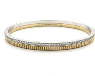 This elegant bracelet is crafted in solid 18K yellow gold and white gold and features a refined diamond-set design with structured radiant detailing. The contrast between the polished white gold diamond row and textured yellow gold base reflects exceptional craftsmanship and modern sophistication. A highly recognizable and collectible fine jewelry piece suitable for both everyday wear and formal occasions.