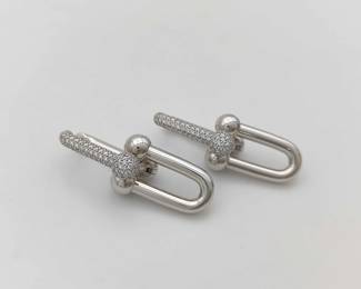 Striking Tiffany & Co. HardWear Large Link earrings crafted in solid 18K white gold and accented with pavé-set diamonds. The bold industrial-inspired link design is enhanced with diamond pavé detailing, creating a powerful yet refined statement piece. A standout creation from Tiffany’s iconic HardWear collection known for its modern architectural style.