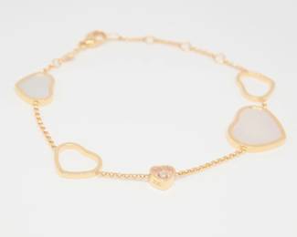 Iconic Chopard Happy Hearts bracelet crafted in solid 18K gold, featuring elegant heart motifs including luminous mother of pearl and the collection’s signature floating diamond element enclosed within sapphire crystal. The refined open heart design symbolizes love and femininity, while the freely moving diamond adds brilliance and motion. A recognizable and timeless piece from Chopard’s celebrated Happy Diamonds Happy Hearts collection.