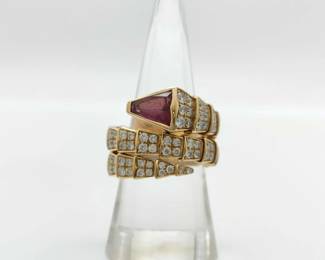 This elegant Bulgari Serpenti ring is crafted in solid 18K gold and features the iconic snake motif, set with a vivid pink tourmaline gemstone displaying rich color and exceptional brilliance. Brilliant pavé-set diamonds accent the serpent’s form, enhancing the dimensional design and creating striking contrast and sparkle. Featuring a distinctive gemstone combination and limited production design, this ring represents a more collectible and desirable example from Bulgari’s celebrated Serpenti collection.