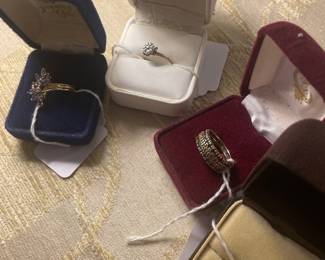 From right to left: 10k and tanzanite ring, half carat diamond cluster ring, emerald, diamond, and emerald eternity band set, and quarter carat diamond wedding set