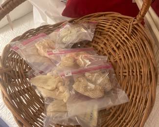 Basket of vintage booties and tatting baby shoes