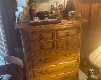 French Provincial oak chest of drawers with old wicker Arts and Crafts lamp and vintage children’s books and marble collection