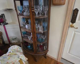 Curio cabinet filled with carnival/milk glass and crystal