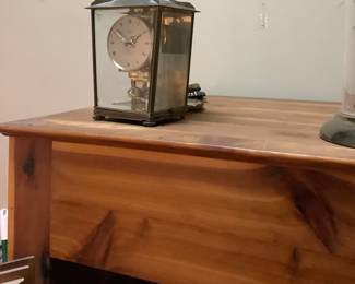 One of the clocks  on tall cedar cabinet.