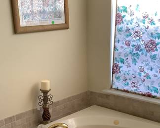 Wood and metal candle holders on tub in master bathroom.