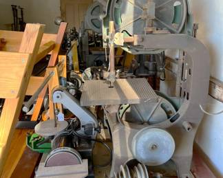 There are a couple of large bandsaws, a disc sander, and a thin belt sander in this photo.