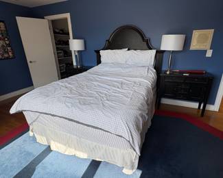 Queen sized bed with traditional style black headboard