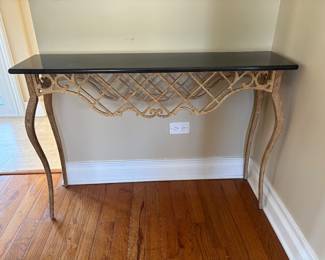 Gold scrolled metal console table with black marble top
