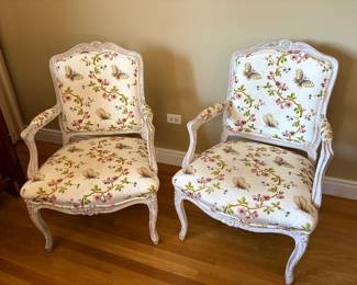 A pair of Louis XV style armchairs with distressed white finished and butterfly fabric