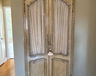 A pretty pair of French country style armoires in pale beige/green, with lots of drawers and shelves