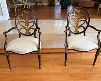 Pair of Hepplewhite style armchairs with oval backs, black and gold finish and ivory cushions
