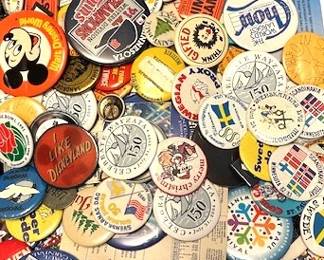 Collection of vintage pin-back buttons, badges, and ribbons.