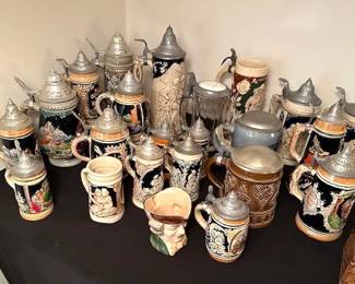 Collection of traditional German Beer Steins, constructed from stoneware, porcelain, or glass.