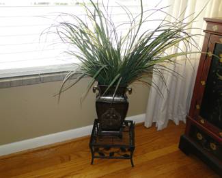 Faux plant on stand, sitting on wooden floor