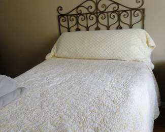 Queen bed with metal headboard, and decorative metal piece above the headboard