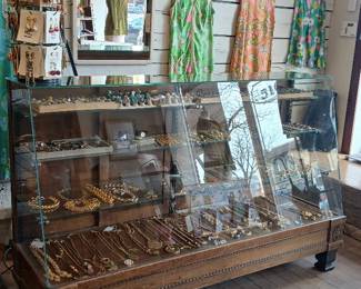 Antique display case, costume jewelry, and sterling silver jewelry.