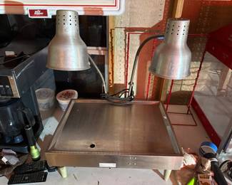 Dual- function heat food warming station. Dual adjusting heat lamps. Control knob for heated base surface