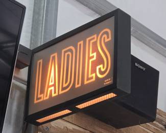 retro-style lighted signage for a women's restroom