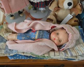 Collectible Doll wrapped in a pink blanket
