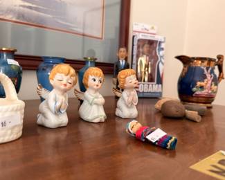Choir angel figurines with Obama bobblehead and Asian figurines