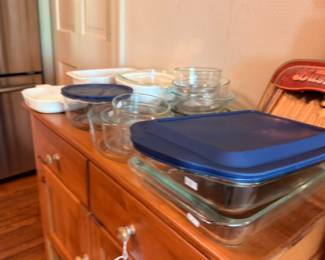 Pyrex glass storage containers with blue lids and casserole dishes