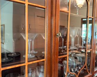 China cabinet full of crystal stemware martini and wine glasses