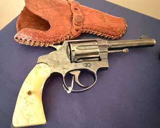 Antique revolver with pearl grip and tooled leather holster