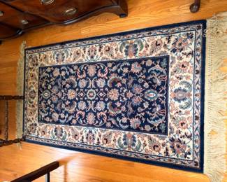 Navy blue oriental area rug with floral pattern and fringe